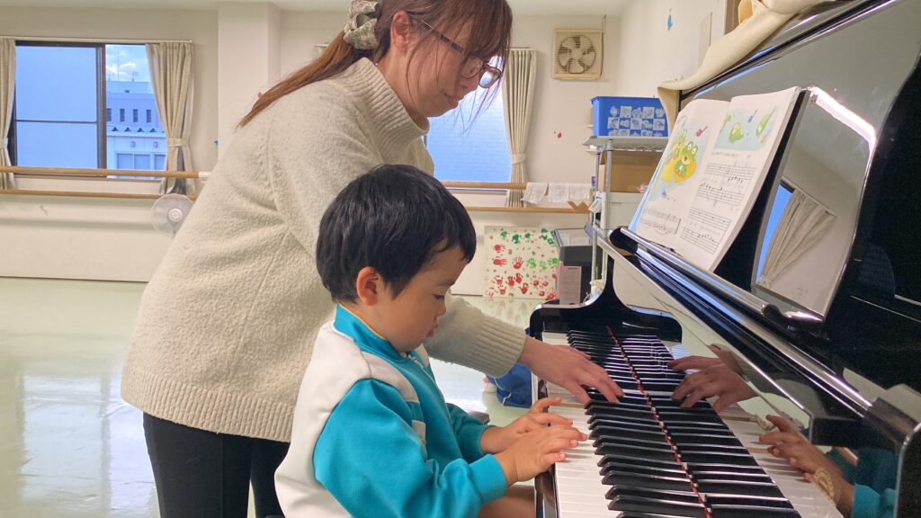 ピアノレッスンをする男の子と講師